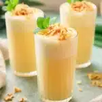 Pineapple Soda Recipe | Amazing Tropical Summer Drink 9 Creamy pineapple soda topped with toasted coconut and fresh mint in tall glasses