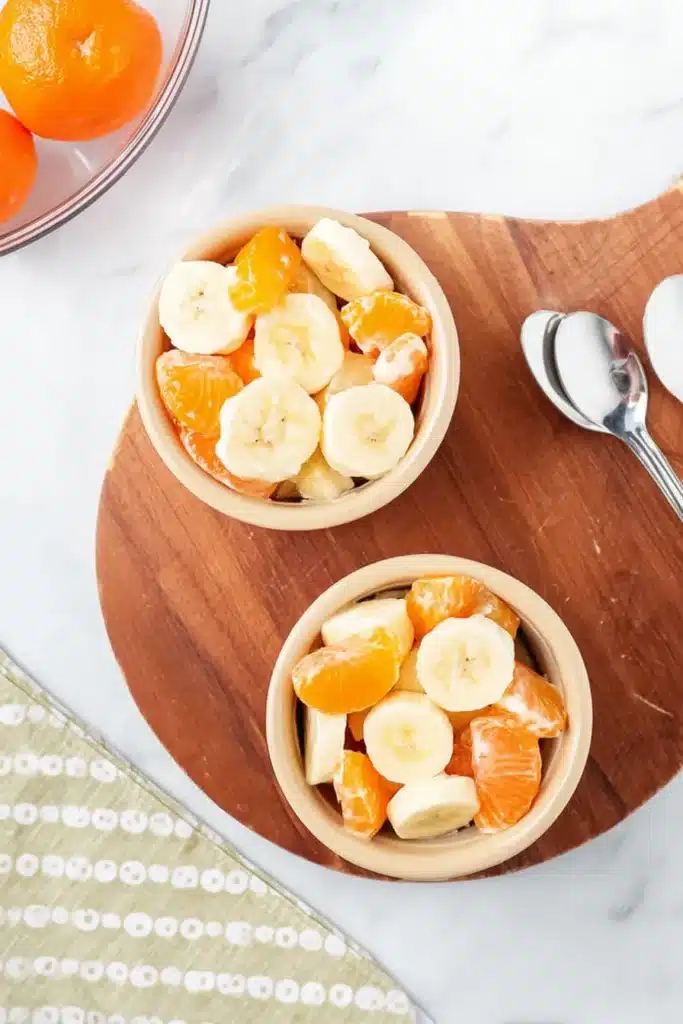 Overhead view of Sunshine Salad served in bowls with pineapple, bananas, and mandarin oranges