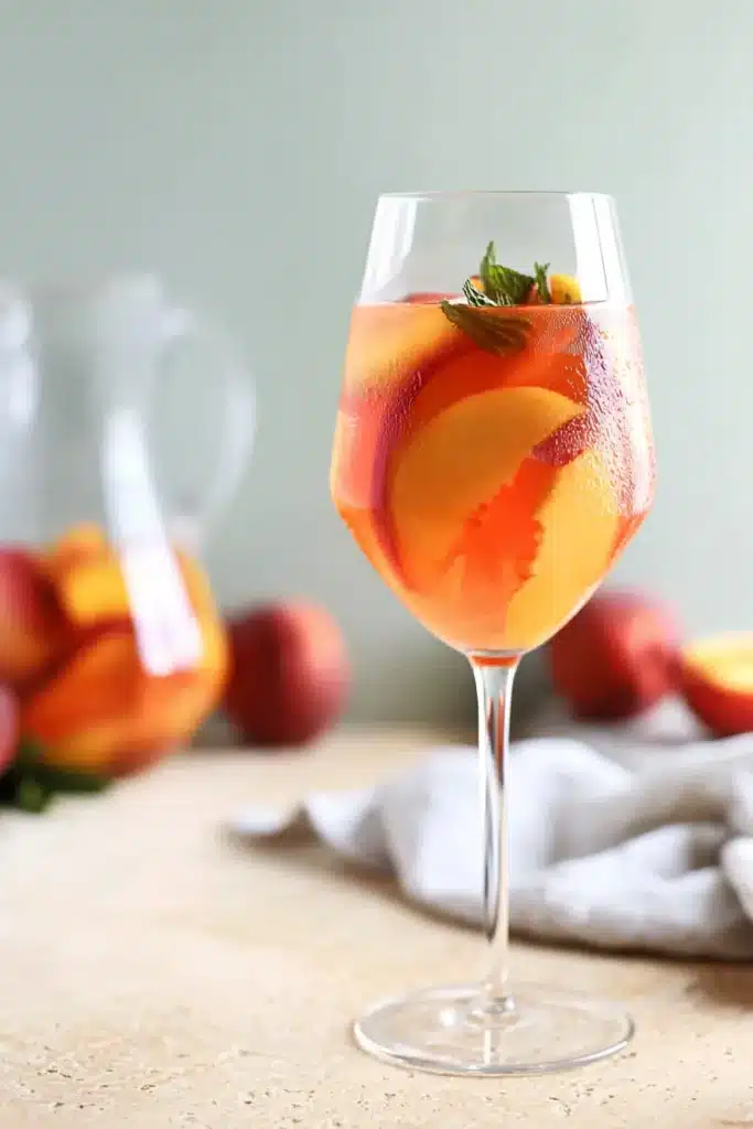 White Peach Sangria with fresh peach slices in a chilled summer wine cocktail