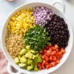 Mexican Quinoa Salad | Amazing Easy Lunch Recipe 7 Mexican quinoa salad with black beans, avocado, corn, tomatoes, and cilantro in a serving bowl