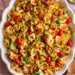 Cheese Tortellini with zucchini, corn, tomatoes, basil, and marinara in a rustic serving dish.