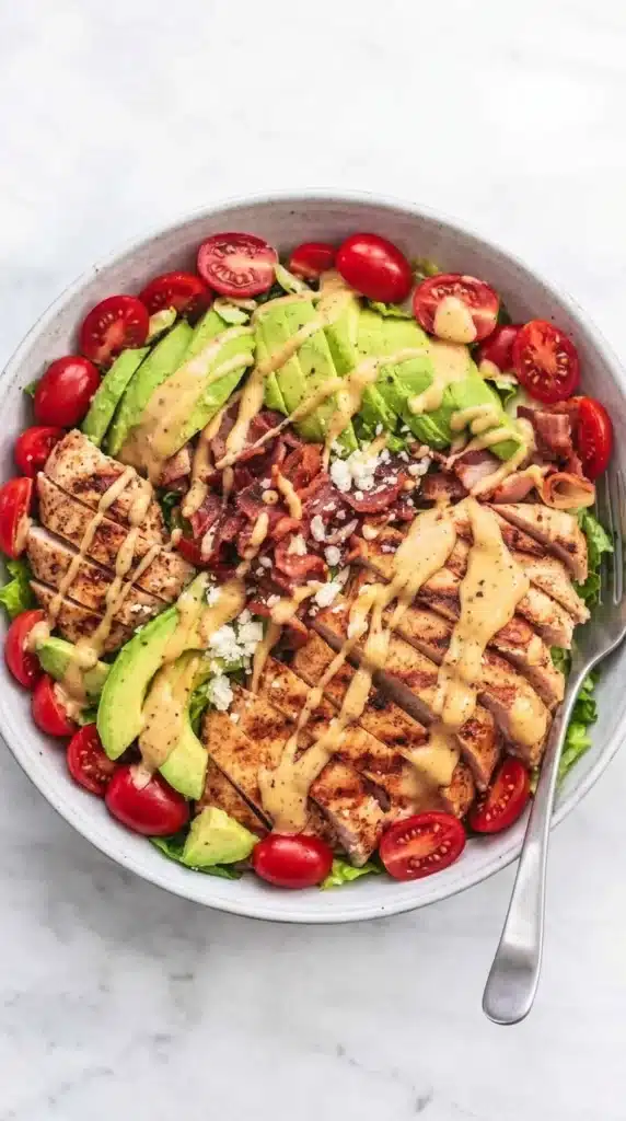 Chicken Avocado Salad served with grilled chicken, avocado, bacon, and Honey Dijon dressing