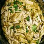Tender Crockpot Salsa Verde Chicken with shredded chicken, green salsa, and fresh cilantro.