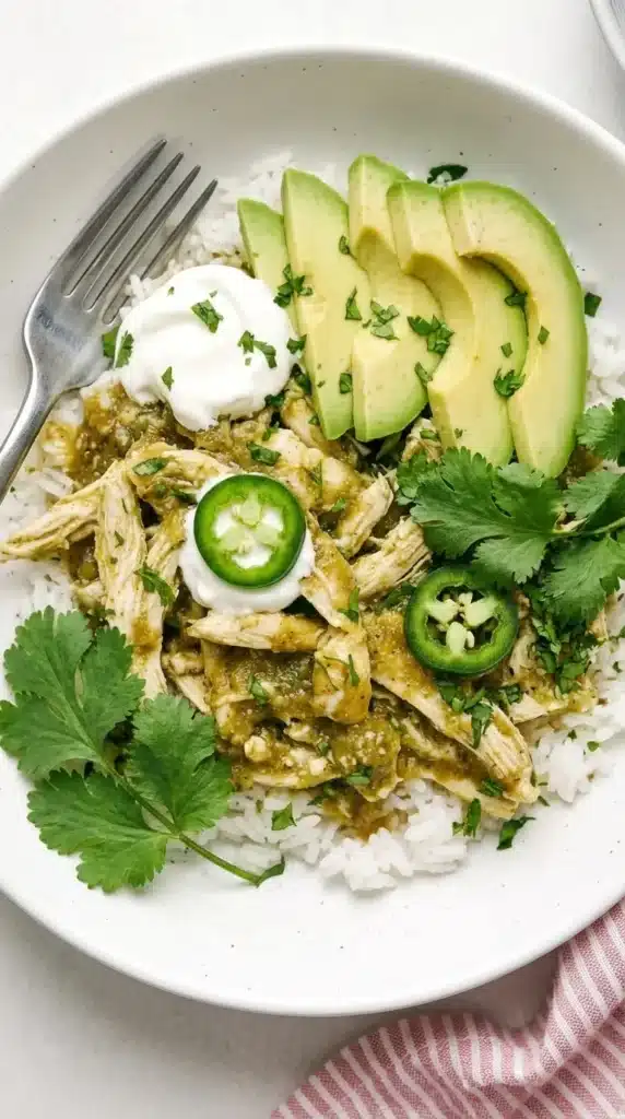 Finished Crockpot Salsa Verde Chicken shredded in green salsa and topped with cilantro.