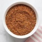 Fajita Seasoning Recipe | Amazing Easy Homemade Blend 7 Homemade Fajita Seasoning in a ceramic bowl with a spoon on a light stone surface