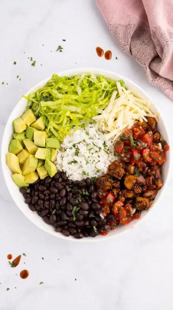 Honey Chipotle Chicken bowl with rice, black beans, avocado, salsa, lettuce, and cheese
