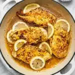 Lemon Pepper Chicken Recipe | Amazing Easy 15 Minute Dinner 7 Golden Lemon Pepper Chicken in a skillet with garlic butter sauce and fresh lemon slices.