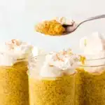 Creamy pumpkin chia seed pudding in a glass jar topped with whipped cream and cinnamon.