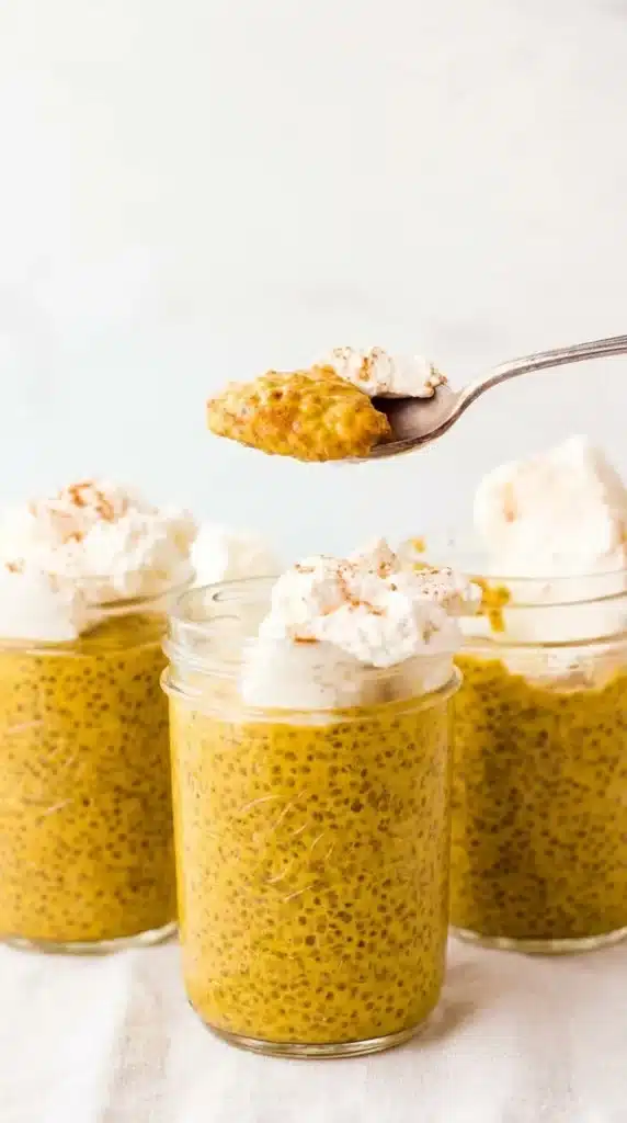 Creamy pumpkin chia seed pudding in a glass jar topped with whipped cream and cinnamon.