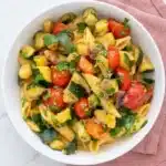 Tomato zucchini pasta with cherry tomatoes, zucchini, parsley, and penne in a fresh summer bowl