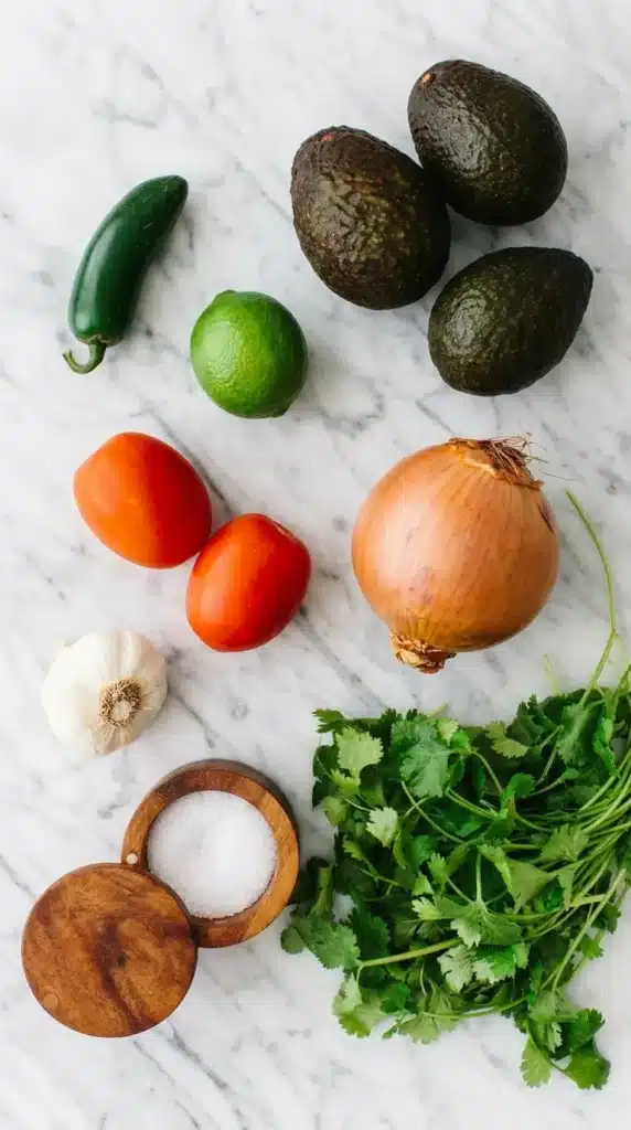 Best Ever Guacamole ingredients arranged on a stone countertop