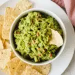 Best Ever Guacamole served in a ceramic bowl with crispy tortilla chips
