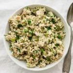 Broccoli tuna salad with fresh herbs, green onions, and sunflower seeds in a bowl
