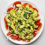 Tomato Avocado Salad with juicy tomatoes, creamy avocado, onion, parsley, and lemon dressing