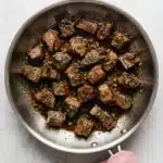 Garlic Butter Steak Bites with seared beef, garlic, shallots, and fresh herbs in a skillet