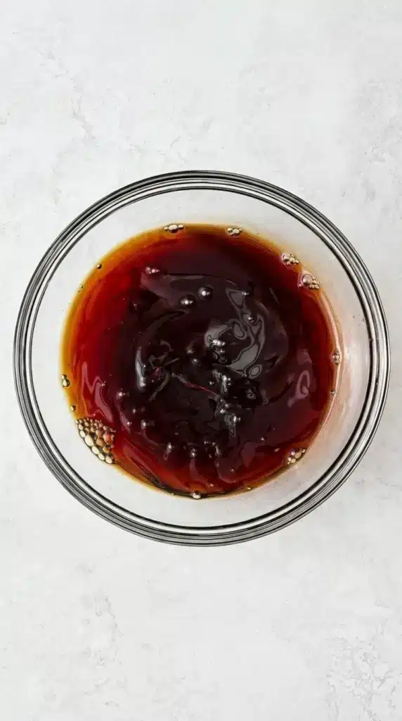 Teriyaki Chicken sauce with tamari, sake, mirin and honey being whisked in a glass bowl