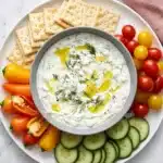 Creamy homemade tzatziki with cucumber, dill, olive oil, fresh vegetables, and pita