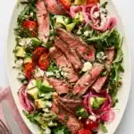 Juicy grilled steak salad with arugula, avocado, blue cheese, tomatoes, and balsamic vinaigrette