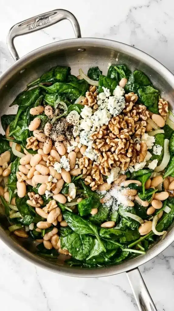 Warm Spinach and White Bean Salad Recipe : Easy & Vibrant 7 Warm Spinach and White Bean Salad with Gorgonzola and walnuts cooking in a skillet