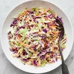 Homemade coleslaw with crisp cabbage, carrots, and creamy tangy dressing