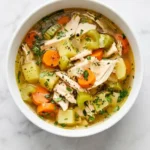 Homemade Turkey Soup with shredded turkey, potatoes, carrots, celery, and fresh parsley