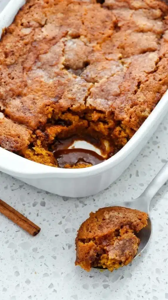 Pumpkin cobbler with soft spiced cake and gooey caramel sauce served warm from a baking dish