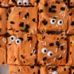 Halloween sugar cookie bars with orange buttercream, spooky sprinkles, and candy eyeballs