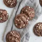 Hot Chocolate Cookies with Chocolate Chips and Marshmallows 7 Hot Chocolate Cookies with chocolate chips and marshmallow bits on a textured surface
